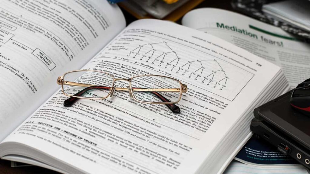 Open book with reading glasses for CAT 2025 preparation