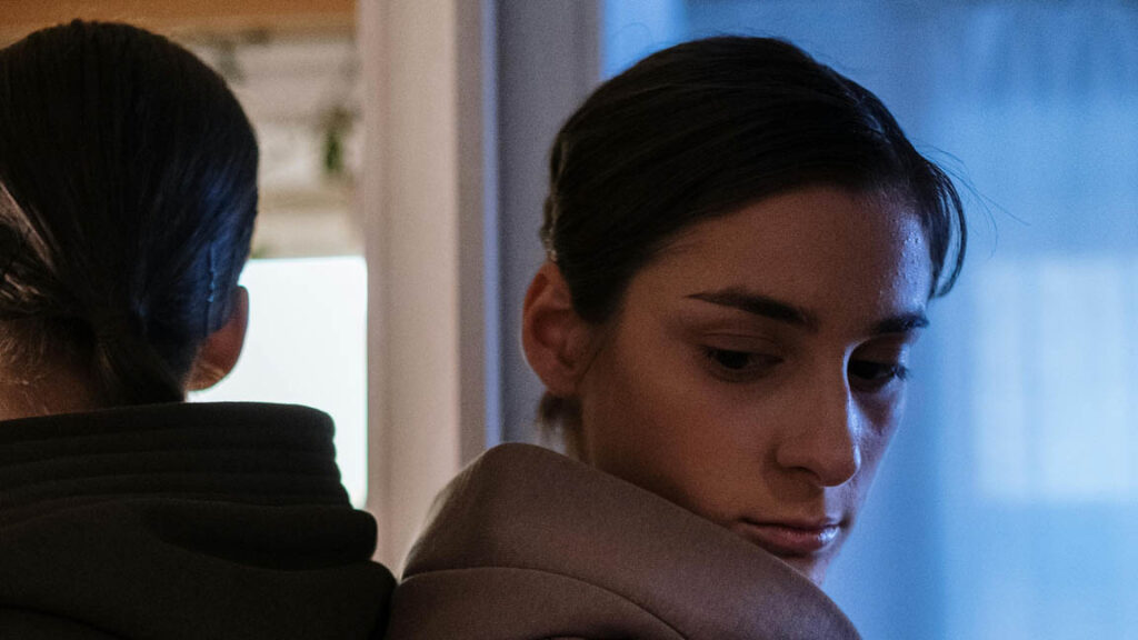 woman looking over her shoulder with doubt, reflecting emotional isolation and paranoia