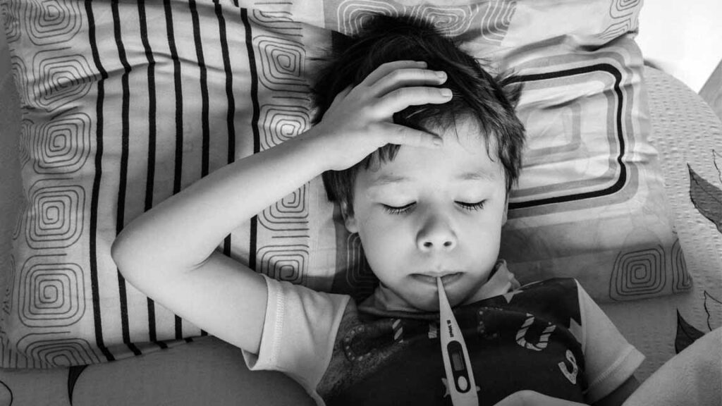 Child with fever and thermometer due to pneumonia